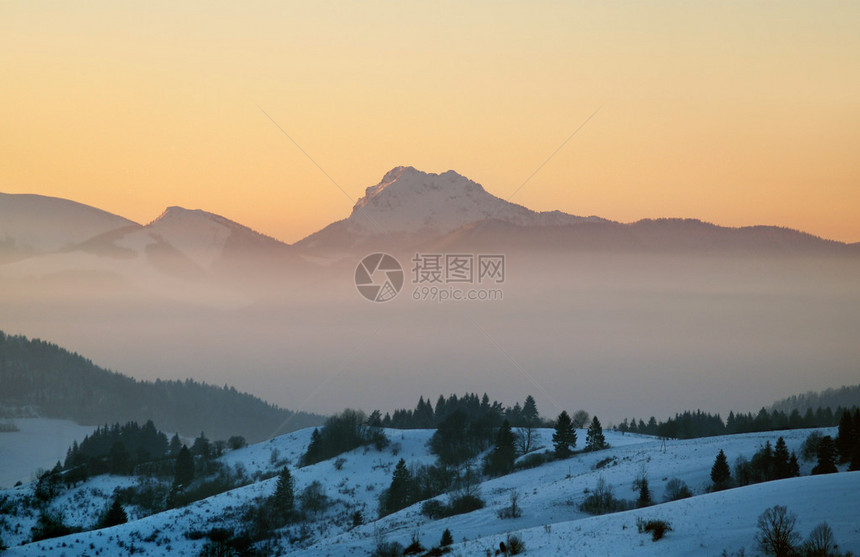 从Jasenovskebralo的山丘上看日落期间VelkyRozsutec峰图片