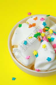 黄色背景上白色杯子里的冰淇淋图片