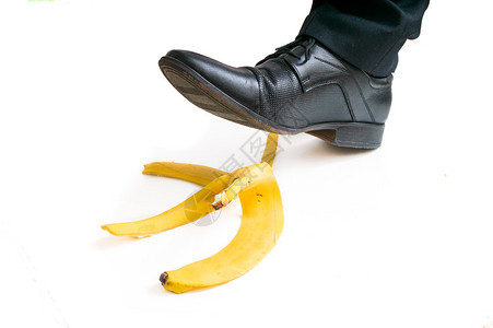 不经意的走路的商人会在香蕉皮上滑倒背景