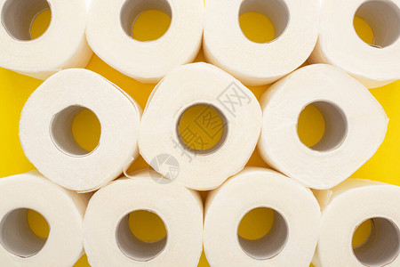 黄色背景上白色卫生纸卷的顶视图图片