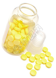 白色背景上有黄色药丸的玻璃瓶图片