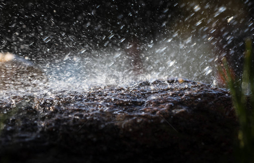 雨中的湿石头雨水滴落到石头上水在他们周图片