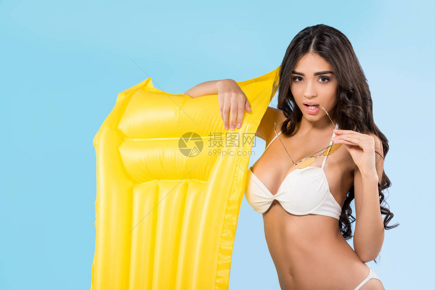 穿着黄色充气床垫的有吸引力的女孩在蓝图片