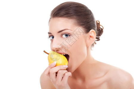 美丽的年轻女人从黄色的梨子上咬人背景图片
