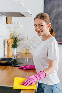 穿着粉红色橡胶手套清洁厨图片
