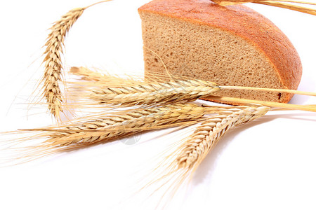 白色背景上的面包和小麦秸秆图片