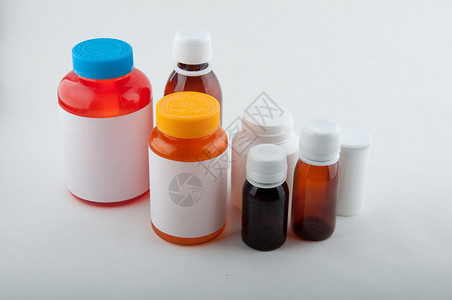 白色背景药丸和胶囊的医用彩色塑料瓶图片