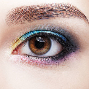 人类女眼睛的特写镜头具有自然晚装时尚面部美容妆的女人完美皮肤和淡紫色蓝色黄背景图片