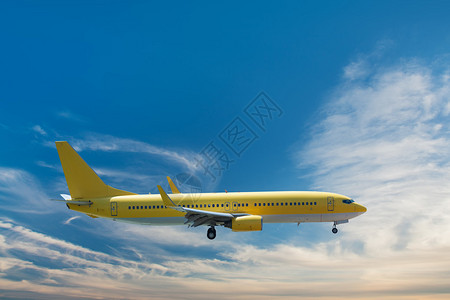 黄色飞机降落在蓝天背景图片