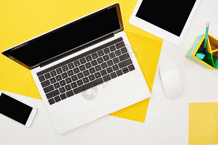 笔记本电脑数字平板电脑带空白屏幕的智能手机以及黄色和白色背景图片