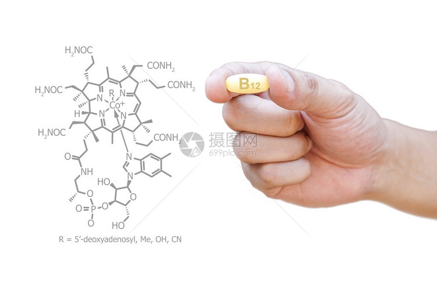 手拿着维生素B12丸与剪报图片