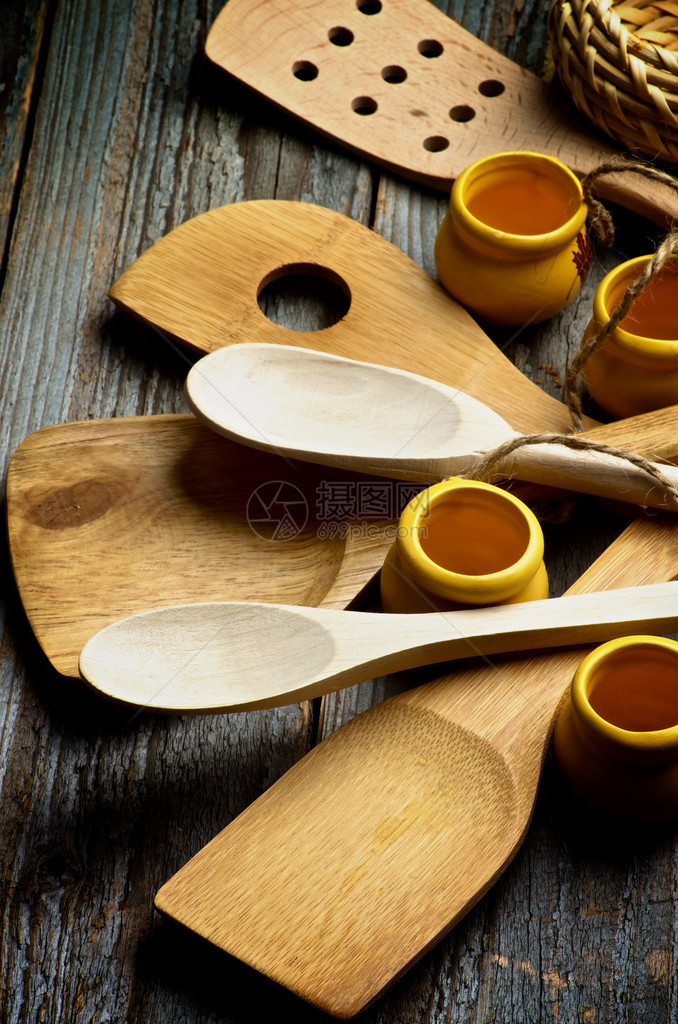 与木制勺子斯帕图拉和小水壶一起安排关于鲁斯蒂克木制背景的厨房Ut图片