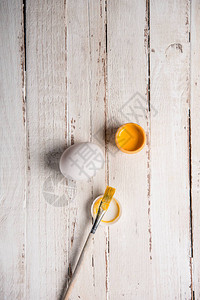 白色鸡蛋和用刷子打开黄色古纳油彩漆容器的图片