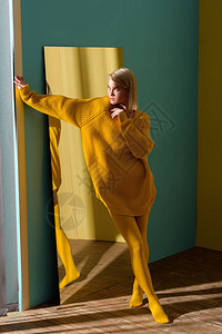 穿着黄色毛衣和紧身裤的时装金发美女图片