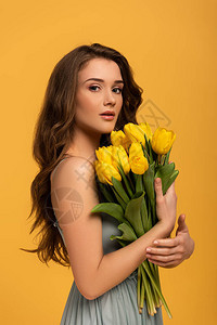 穿着春装的有魅力女人拿着黄色隔背景图片