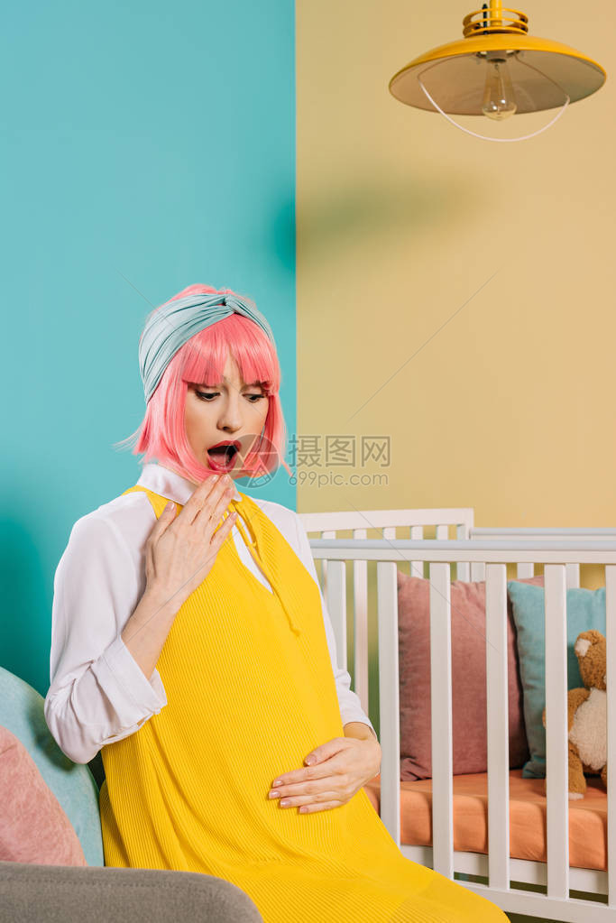 震撼在儿童房间的婴儿床旁坐着粉红色头发图片