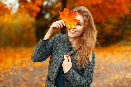 美丽的快乐女人在秋天公园里有着明图片