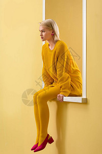 穿粉红色鞋黄色毛衣和穿着装饰窗户的紧身衣服的时图片
