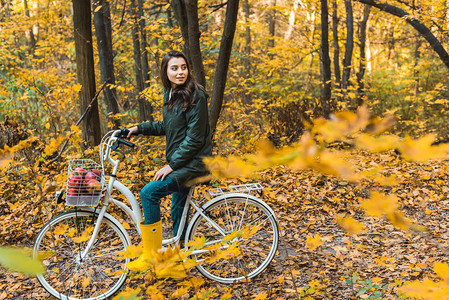 快乐的年轻女子坐在自行车上图片