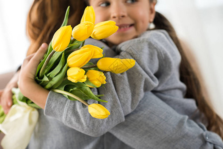 持黄色郁金香和抱母亲的可图片