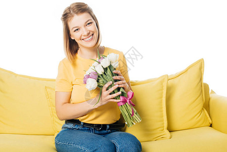 美丽的微笑着女人的肖像与白色隔绝的黄色沙发图片