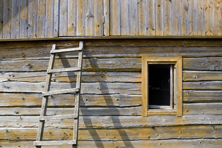 老村屋背景的黄色木裂墙窗户和楼梯图片