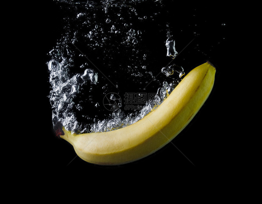 香蕉在黑色背景下坠入水中空气泡在图片