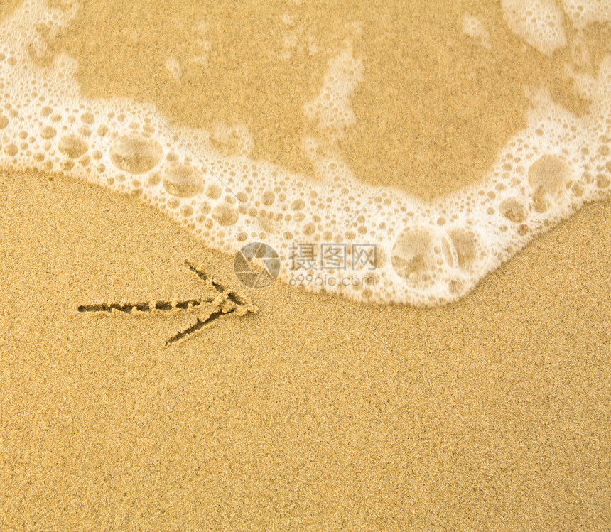 箭头写在沙滩上海浪柔和图片