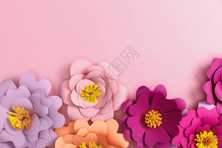粉红色背景纸彩花的顶视图图片