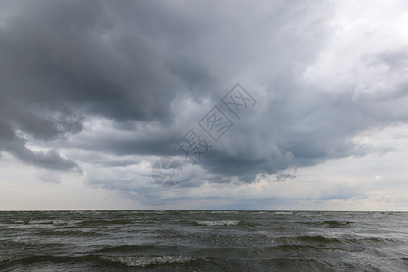 在风雨如磐的天空的沙滩上的海浪图片