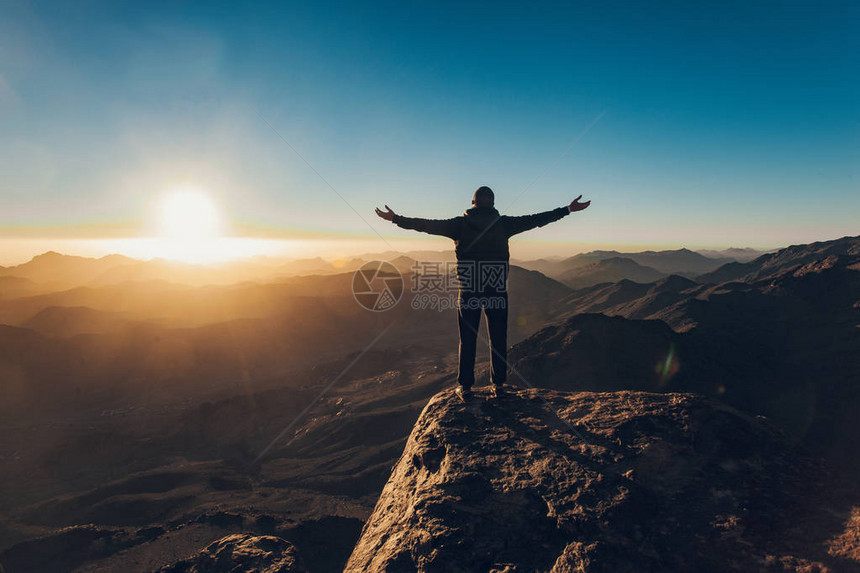人站在朝阳在埃及的西奈山上冥想图片