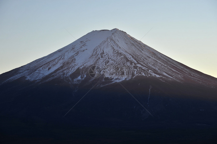 一抹淡黄色的夕阳照在富士山上图片