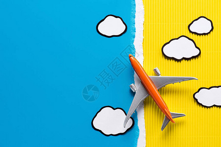 黄色和的玩具平面和纸云顶部视图片