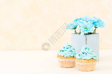 蛋糕与蓝色奶油装饰和复古破旧别致花瓶中的蓝色菊花图片