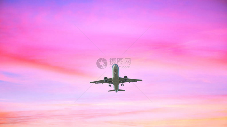 飞机降落在有色面粉的天空背景上日落天空以粉色图片