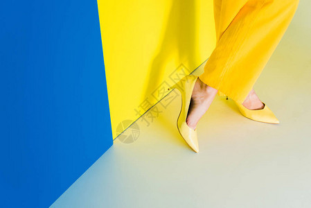 蓝色和黄色背景的皮鞋中女脚图片