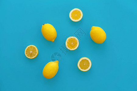 黄色柠檬和柠檬片放在亮蓝色的纸上图片