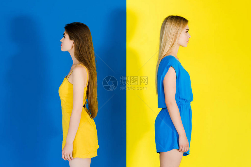 有吸引力的年轻女孩背靠站在蓝色和黄图片