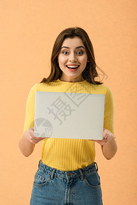 奇怪的黑发女孩拿着笔记本电脑在橘子上图片