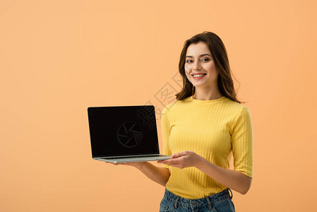 深褐色女孩穿着笔记本电脑在橙色上背景图片