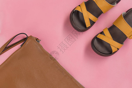 粉红色背景中的皮革手提包和黄色休闲鞋图片