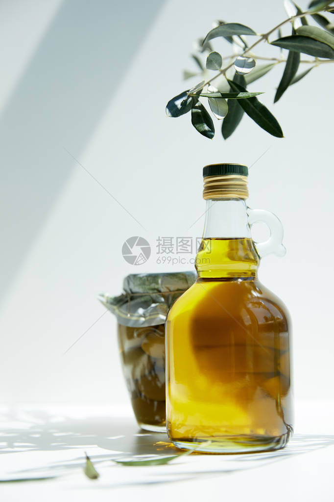 瓶装香味橄榄油树枝和罐子图片