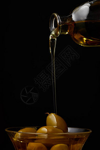 橄榄油倒进碗里用瓶子的橄榄图片