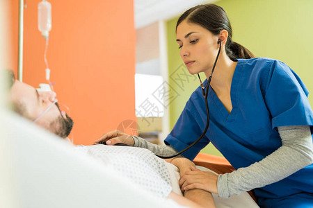 西班牙裔女医生在医院用听诊器检查病人图片