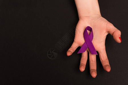 黑色背景上捧着紫色丝带的女生手部图片