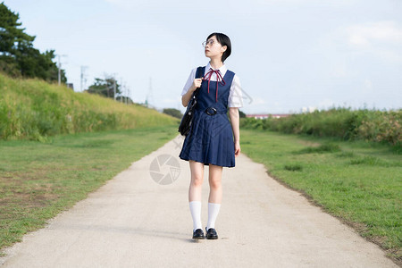 漂亮的女学生在户外路上行走图片