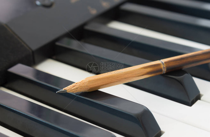 电动钢琴在交叉视角中的黑键的老旧硬币关于钢琴演奏或钢图片