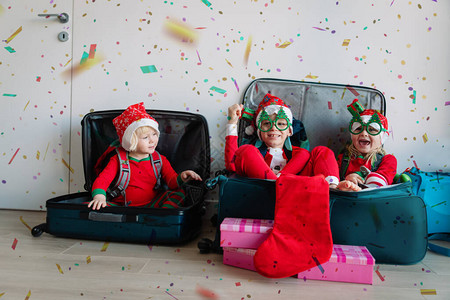 快乐的孩子们为圣诞节旅行打包行李图片