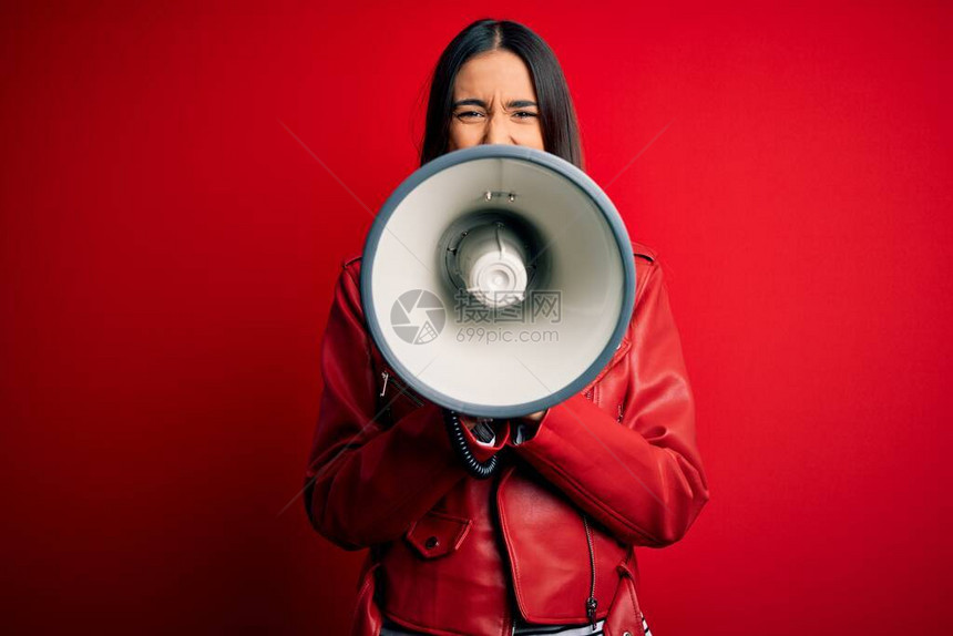 红色背景前对着镜头拿着扩音器大声抗议的女士图片