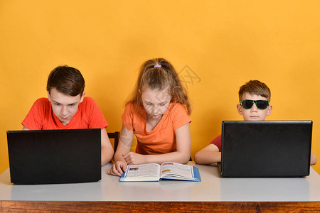 两个男孩坐在笔记本电脑前图片